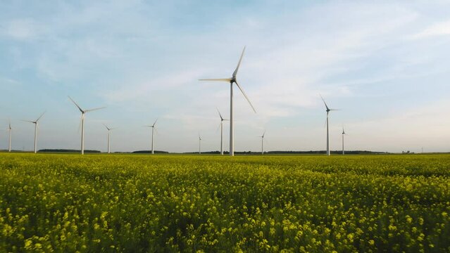 Solar power plant and Windmills aerial view. Renewable energy. Green tech. Farm windmills at sunset. Wind turbines power farm Future technology. Wind power turbines generating. Aerial. Drone. 4K. 