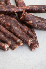South African Dry Wors, a dried and cured sausage snack on grey, with copy space

