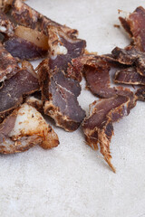 South African Biltong, a dried and cured meat sliced and on grey backdrop with copy space