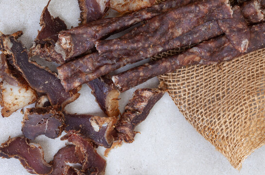 South African Dry Wors, a dried and cured sausage snack on grey, with copy space

