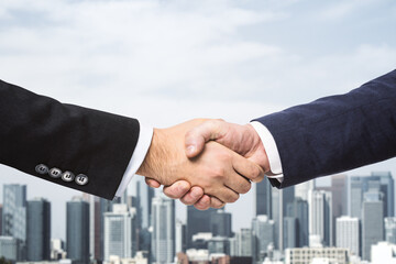 Two businessmen shake hands on the background of city skyline, partnership concept, close up