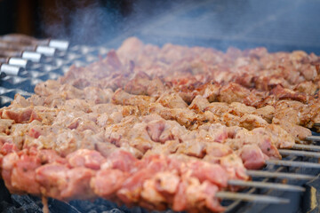 Pork skewers frying on brazier