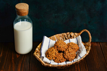 The oatmeal cookies, healthy breakfast cereal oat crackers and milk. Crispy anzac biscuit cookie with oat flakes on rustic table