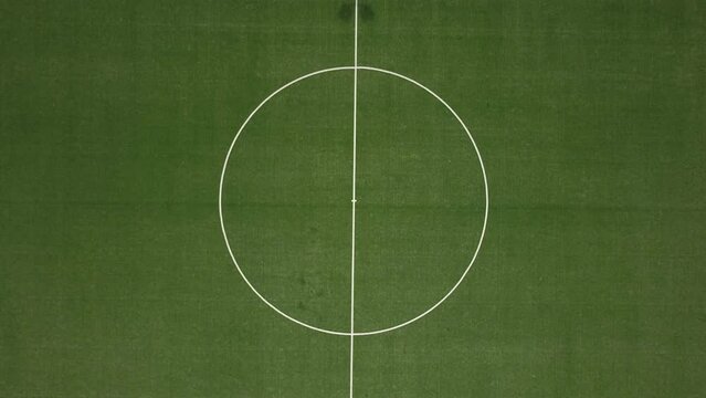 Drone shot of a football field with birds eye view - drone is ascending from the kick off, revealing the whole pitch. Snippet could be used for sports or football related videos or movies.