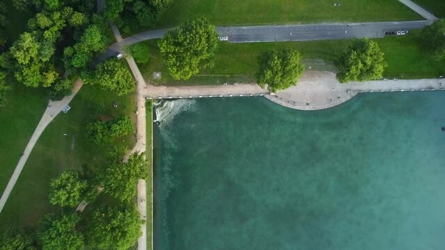 Birds eye view drone shot of Aachener Weiher in Cologne, Germany - drone is ascending, revealing the city vibes surrounding the lake. Snippet could be used for travel related videos or Cologne movies.