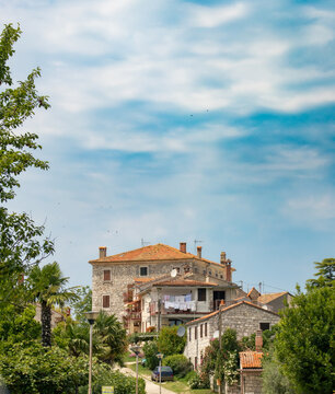 Mediterranean house on a hill with laundry and trees.