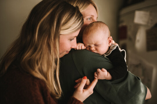 Mothers holding sleeping newborn baby