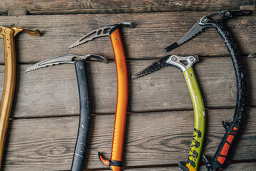 Detail photo of different ice climbing tools. Ice climbing gear, ice axe on a wooden background....