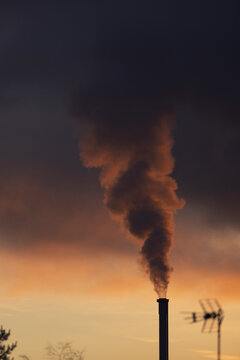 Smoke stack emitting smoke into evening sky