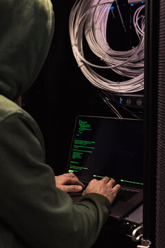 IT technician working on laptop in server room