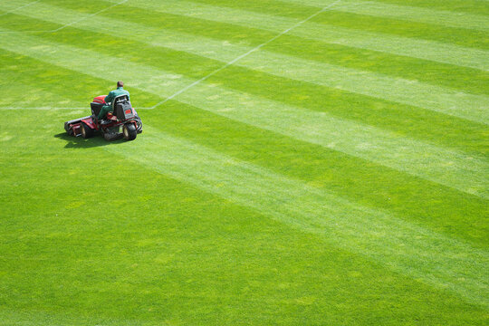 Mowing grass ion the pitch of the football stadium