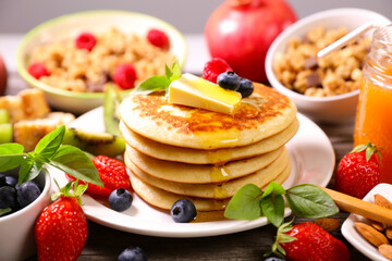 pancakes with berries fruits,  butter and maple syrup