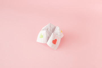 Paper origami fortune teller on pink background. Minimal concept.