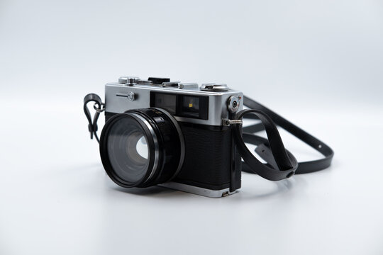 Isolated white background Beautiful vintage analog rangefinder film camera. 70's Decade film camera. Front left view image.