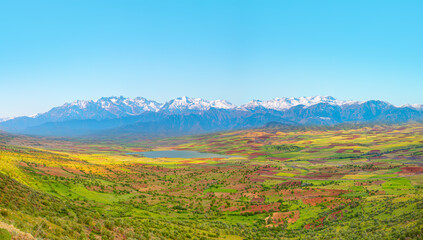 Beautiful blue lake landscape with a view of the mountains and a green valley 