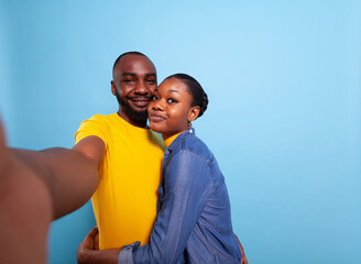 POV of cheerful people holding camera and taking pictures together, expressing love and affection. Man and woman smiling and taking selfies, having fun in relationship. Couple embracing