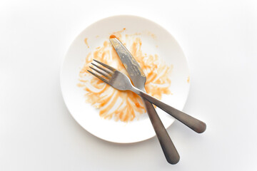 Dirty plate with knife and fork on the table. Photo can be used for the concept of how to clean the...
