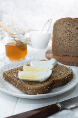 Healthy breakfast with wholemeal bread, fresh goat cheese and raw honey. A delicious breakfast.