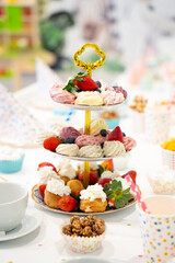 Obraz premium Cake, Candy, Marshmallows, Fruits and Berries, Chocolates, Waffles and other Sweets on Dessert Table at Kids Birthday Party