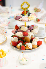 Cake, Candy, Marshmallows, Fruits and Berries, Chocolates, Waffles and other Sweets on Dessert Table at Kids Birthday Party