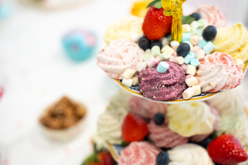 Cake, Candy, Marshmallows, Fruits and Berries, Chocolates, Waffles and other Sweets on Dessert Table at Kids Birthday Party