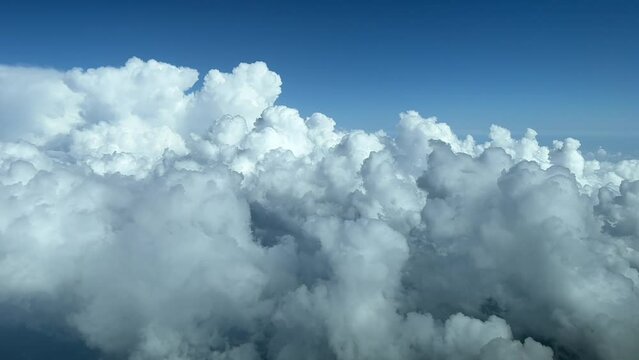 Aerial view from a jet cockpit overflying a sky plenty of white cumulus
