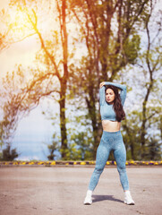 Portrait of beautiful fit woman exercising in the park. Caucasian female fitness model working out in the morning.