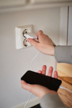 Hands plugging in cell phone charger