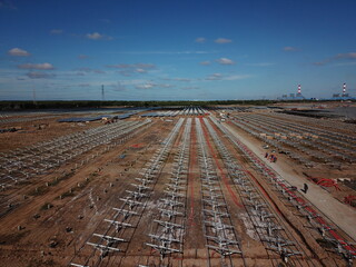 Solar farm under construction with solar panels and empty frames in the background - Green energy...