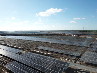 Solar farm under construction with solar panels and empty frames in the background - Green energy and sustainable development concept