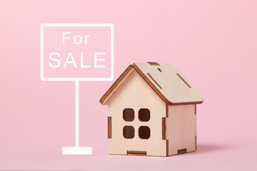House for sale. Real estate purchase and sale concept. Real estate services. Bargain home purchase. Small wooden house on a pink background.	
