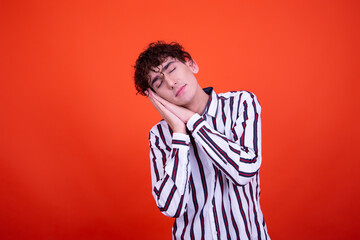 Emotions of a young attractive guy. Orange background.