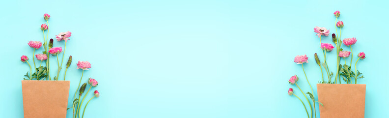 Top view image of pink flowers composition over blue background