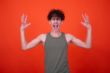 Emotions of a young attractive guy. Orange background.