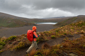 Hiking Tama Lakes track. Lower Tama lake in the distance, Tongariro National Park. - obrazy, fototapety, plakaty