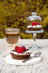Green tea and raspberry cake on a wooden background. Breakfast outside in the fresh air.