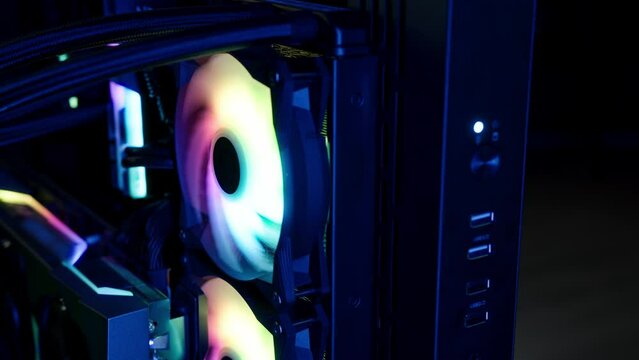 Gaming computer with rgb led colorful lights, modified glowing fan in a pc spinning around, other hardware components. High quality 4k footage