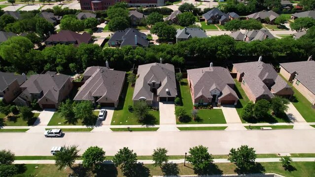 Aerial footage of a neighborhood in Flowermound Texas. Camera fly perpendicular to street.