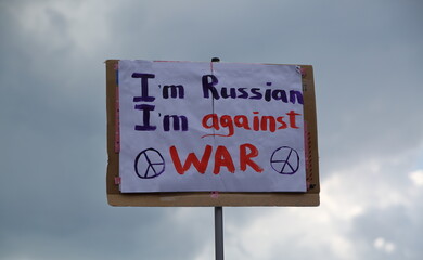 Banner with slogan I AM RUSSIAN I AM AGAINST WAR and peace symbol during demonstration against Russian invasion in Ukraine