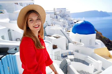 Portrait of fashion girl enjoying view from her resort in Oia village, Santorini, Greece. Young...