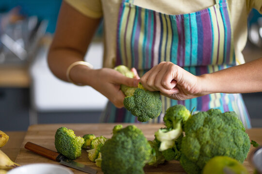 Young woman preparing broccoli for lunch