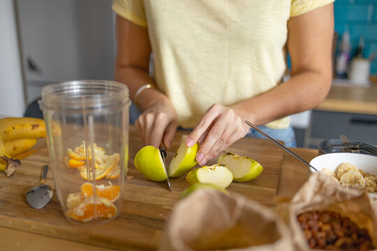 Young woman cutting an apple,  Preparing healthy breakfast