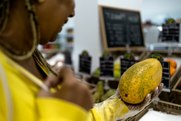 Senior African woman buying fresh fruits in supermarket