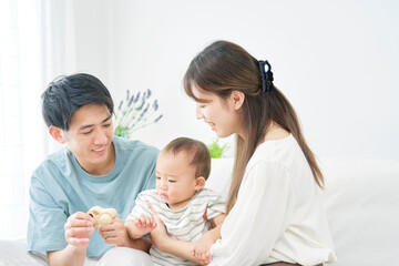 Obraz na płótnie Canvas 赤ちゃんと遊ぶ両親　リビングルーム