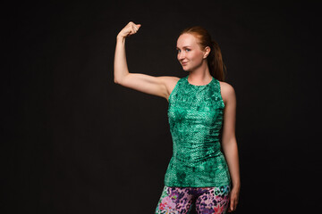 Strong red haired woman in sport uniform posing