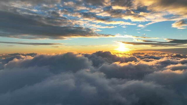 Aerial hyperlapse of magnificent sunset above the clouds. Flying over flying over thick clouds in the rays of the setting sun.