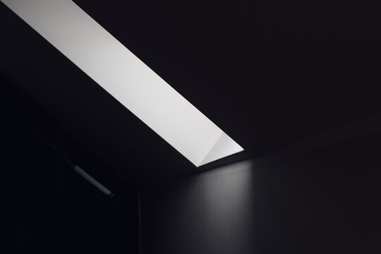 Dark room with strip of light coming from the roof window as abstract background