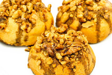 Three molasses cookies decorated with walnuts on a white background