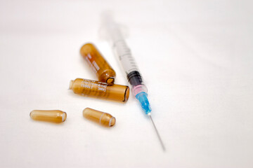 Empty medical ampoules infusion and used syringe after vaccination isolated on white background