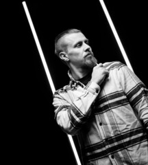 Black and white male portrait in plaid shirt on black background